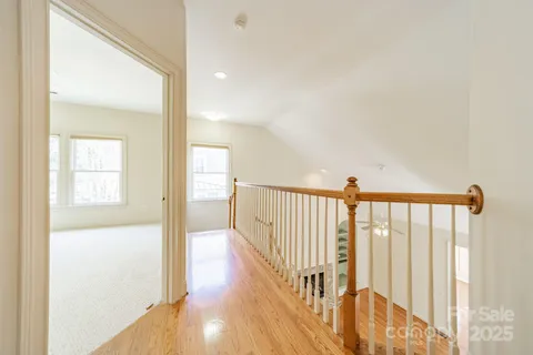 a view of a hallway with wooden floor and staircase