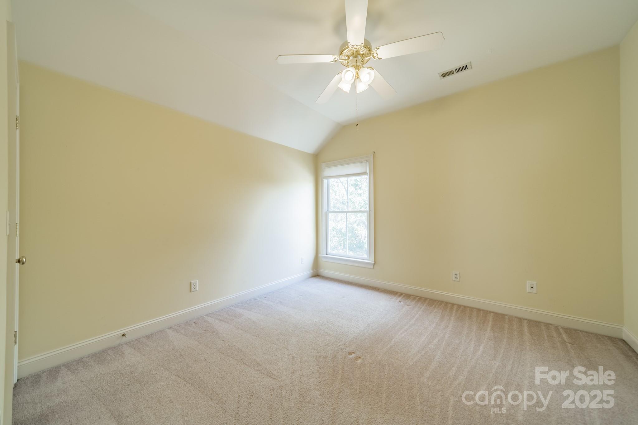 545 Glen Walk Drive Fort Mill, SC 29708 - Photo 31 of 48 an empty room with a chandelier fan and windows