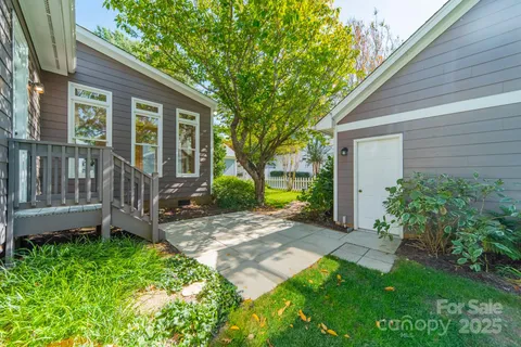 a view of a house with a yard and a large tree