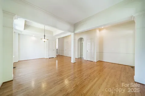 a view of a big room with wooden floor and windows