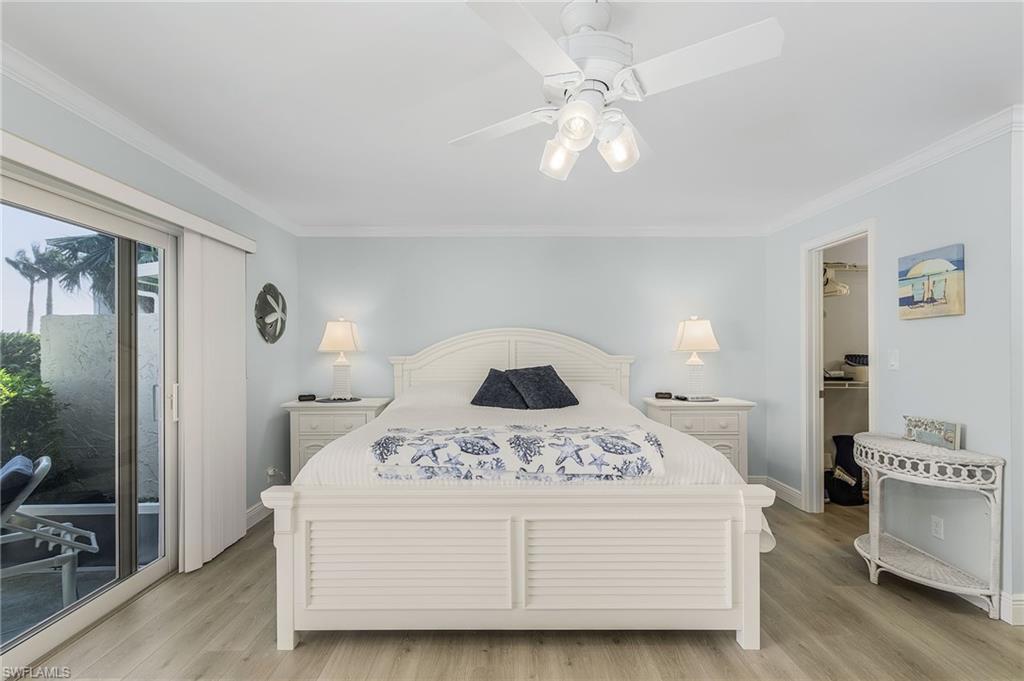 237 Palm Drive, Unit 1 Naples, FL 34112 - Photo 13 of 30 a bedroom with a bed and a chandelier