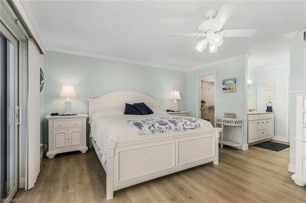 237 Palm Drive, Unit 1 Naples, FL 34112 - Photo 15 of 30 a bedroom with a bed and a chandelier