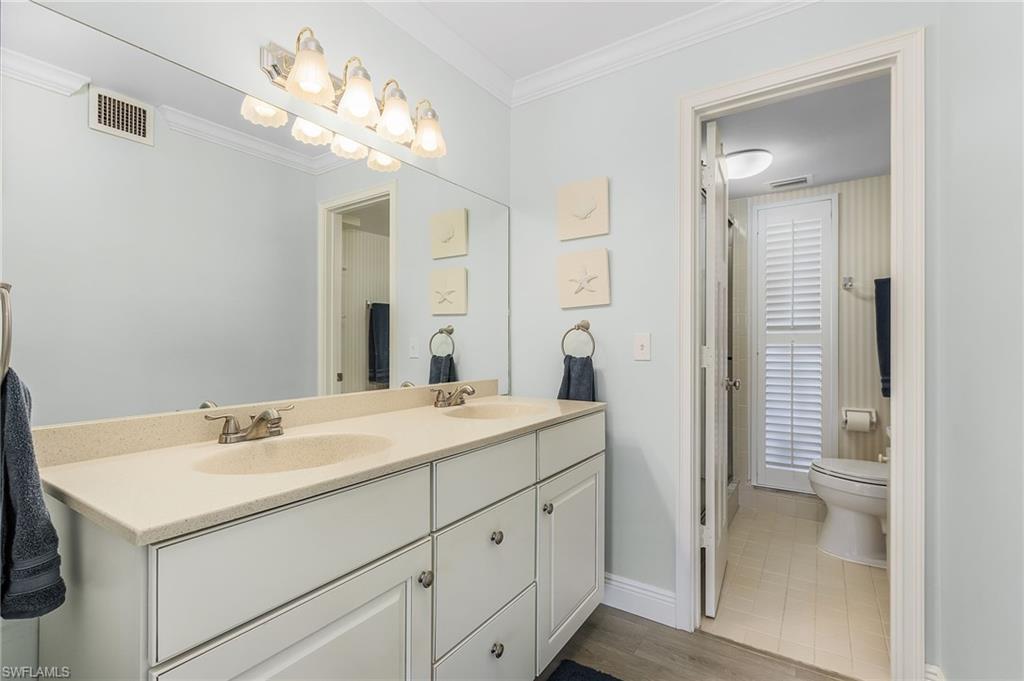 237 Palm Drive, Unit 1 Naples, FL 34112 - Photo 16 of 30 a bathroom with a sink vanity and a mirror