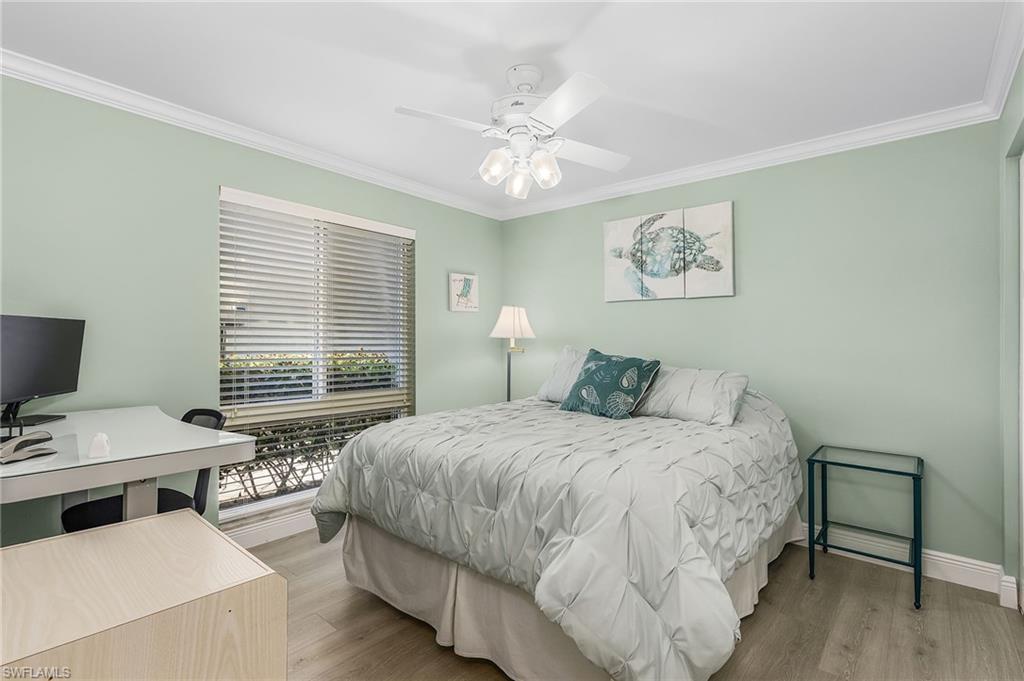 237 Palm Drive, Unit 1 Naples, FL 34112 - Photo 19 of 30 a bedroom with a bed and a chandelier