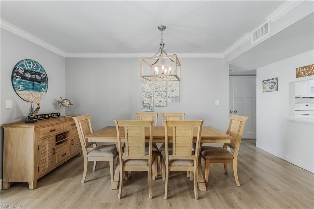 237 Palm Drive, Unit 1 Naples, FL 34112 - Photo 7 of 30 a view of a dining room with furniture window and wooden floor