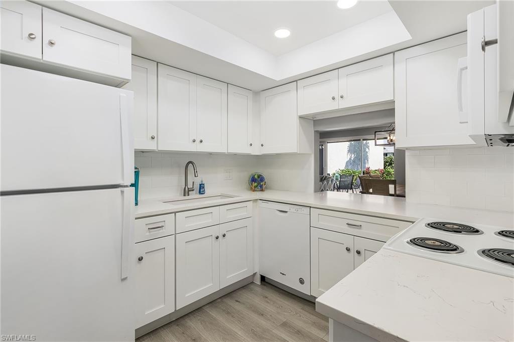 237 Palm Drive, Unit 1 Naples, FL 34112 - Photo 10 of 30 a kitchen with white cabinets and white appliances