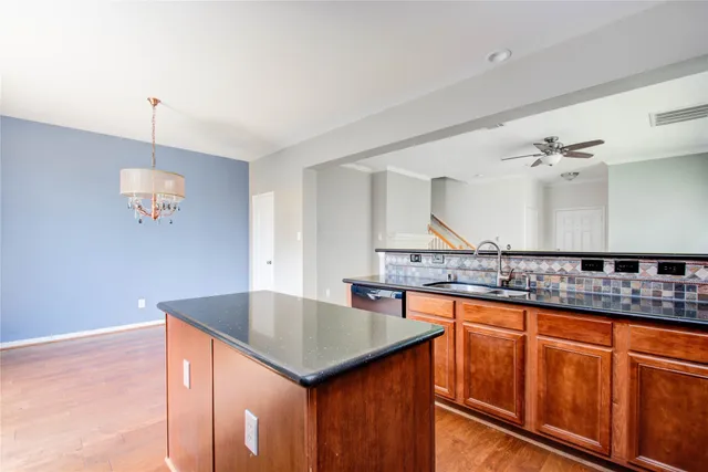 a kitchen with stainless steel appliances granite countertop a sink and a refrigerator