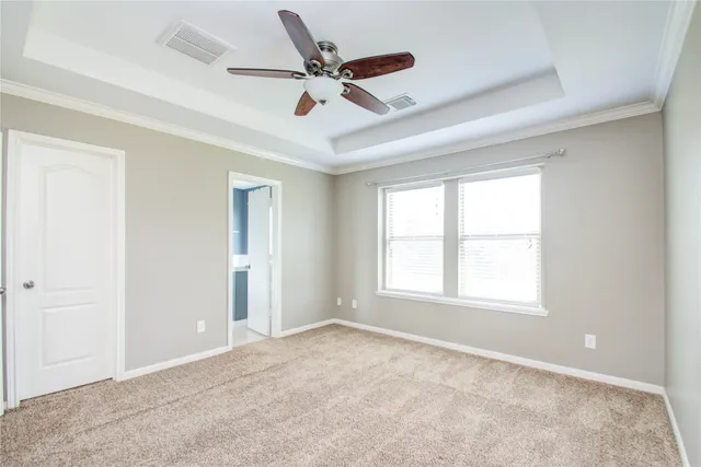 a view of a livingroom with a ceiling fan & windows