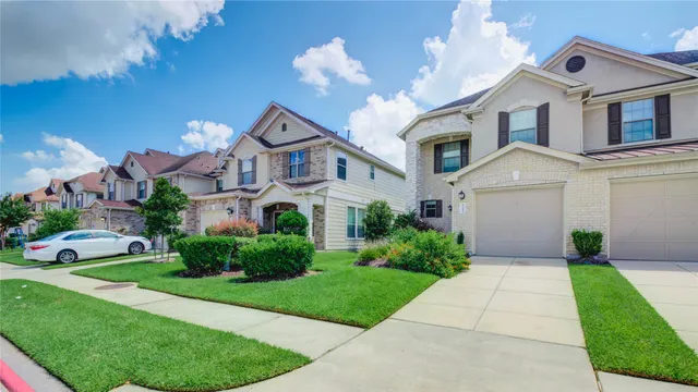 a front view of a house with a yard and potted plants