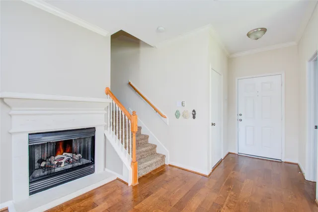 a view of an empty room with wooden floor and a fireplace