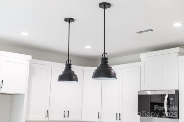 a kitchen with kitchen island a white counter top space cabinets and stainless steel appliances