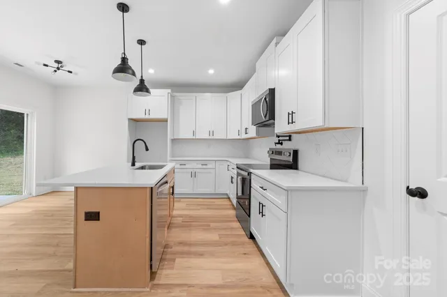 a view of a kitchen with a sink and wooden floor