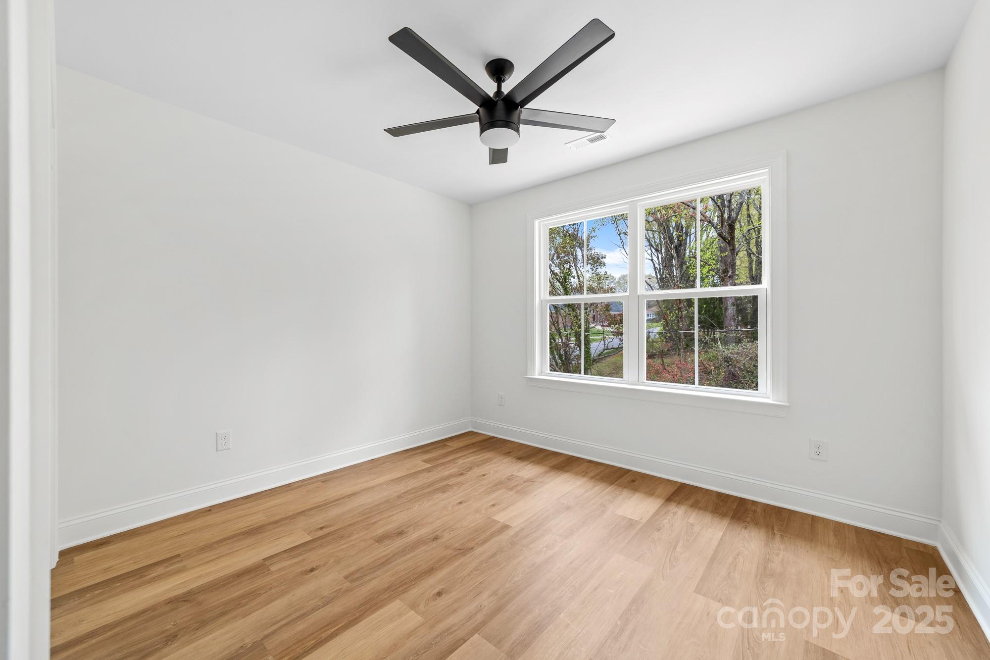 103 West Irwin Street Cherryville, NC 28021 - Photo 22 of 30 an empty room with wooden floor and windows