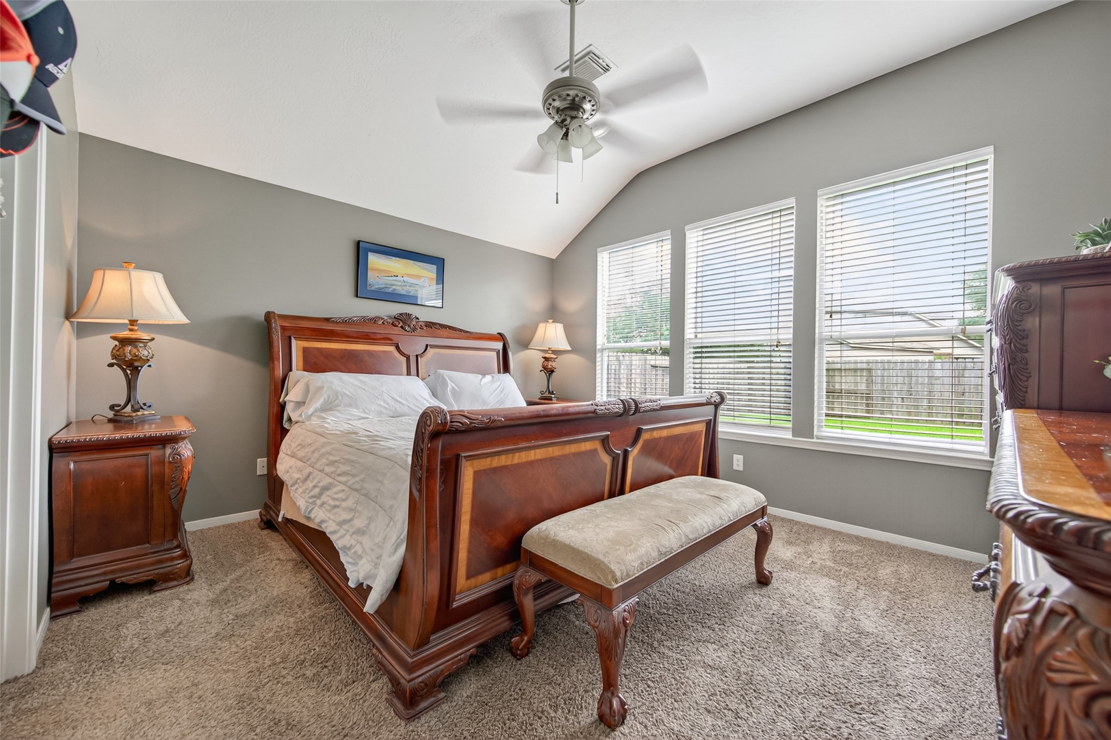 8622 Henrico Lane Rosenberg, TX 77469 - Photo 11 of 20 This cozy bedroom features elegant wooden furniture, a comfortable sleigh bed, plush carpeting, and large windows that provide ample natural light. The neutral walls and ceiling fan add a modern touch.