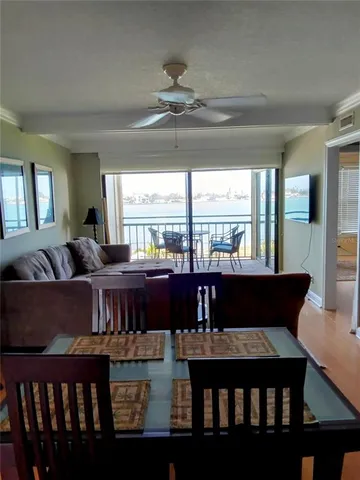 a living room with furniture large window and wooden floor