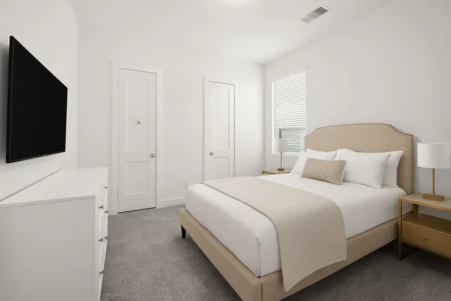 a bedroom with a bed and a flat screen tv