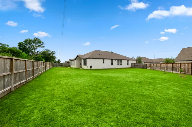 a view of a garden with a house in the background