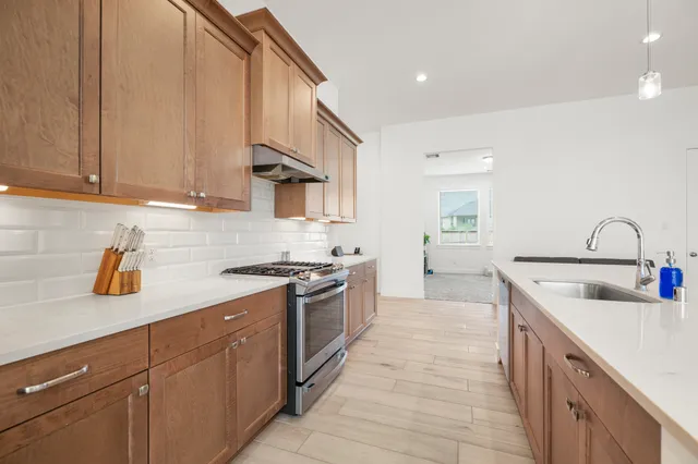 a kitchen with granite countertop a sink a stove and cabinets