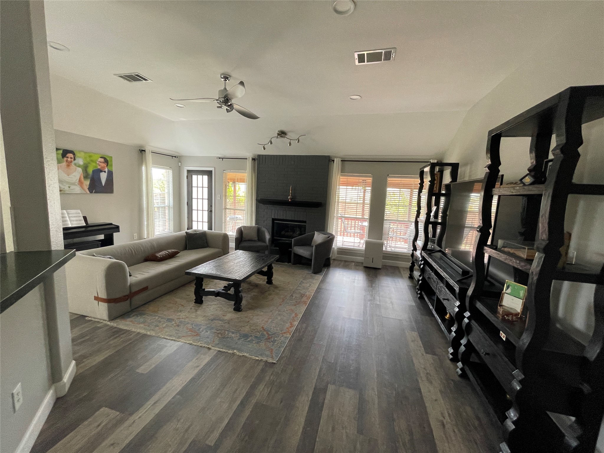 3023 Bent Tree Loop Round Rock, TX 78681 - Photo 4 of 18 Living area featuring ceiling fan, plenty of natural light, vaulted ceiling, dark wood-type flooring, and a fireplace