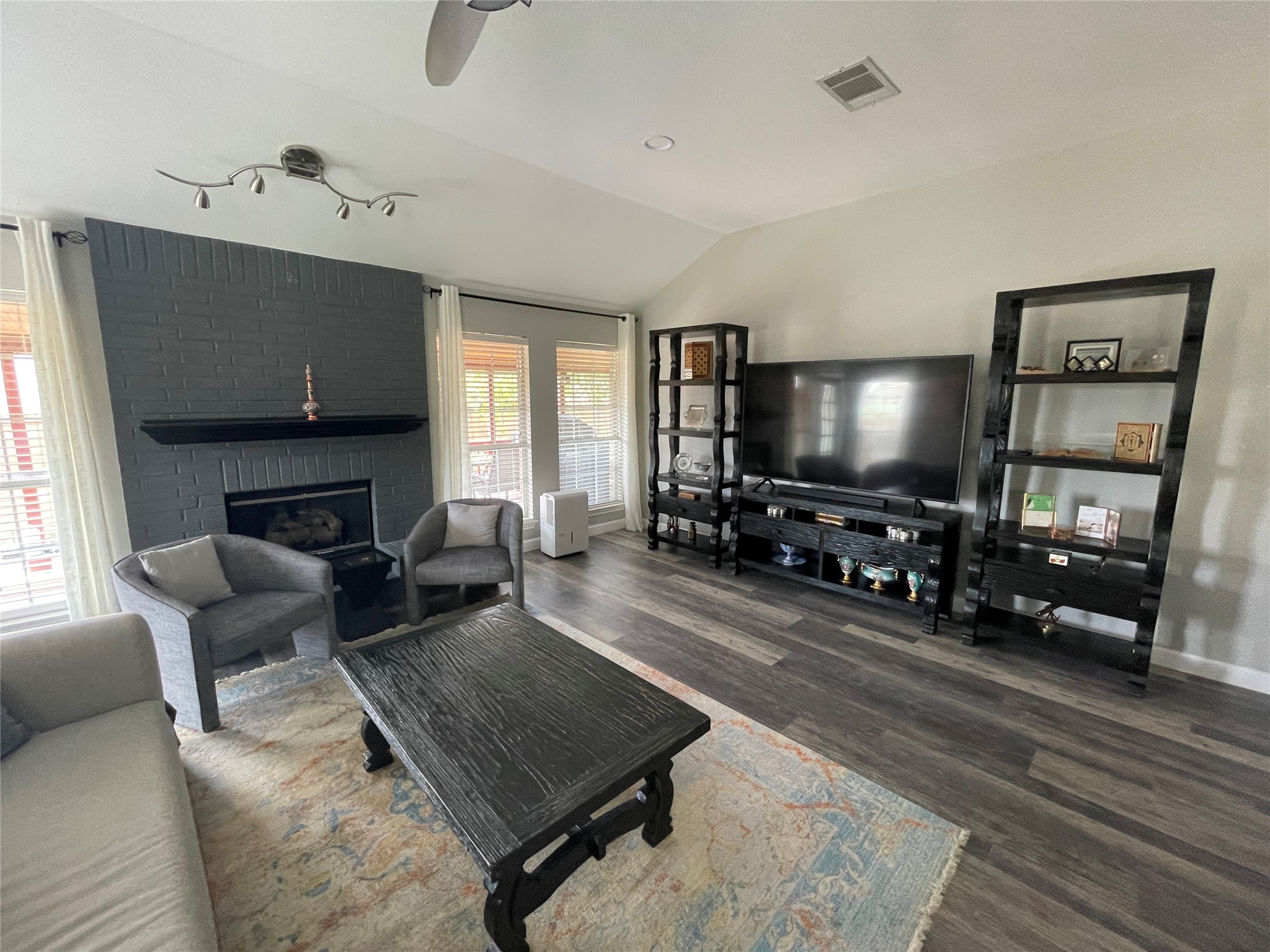 3023 Bent Tree Loop Round Rock, TX 78681 - Photo 7 of 18 Living room featuring vaulted ceiling, dark wood-type flooring, ceiling fan, a fireplace, and recessed lighting