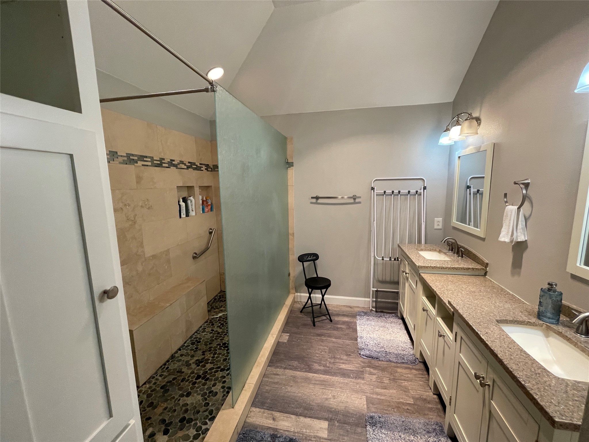 3023 Bent Tree Loop Round Rock, TX 78681 - Photo 10 of 18 Full bath featuring double vanity, dark wood-style flooring, vaulted ceiling, and a walk in shower