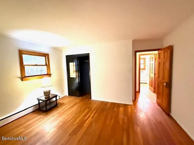 a view of a room with wooden floor and a window