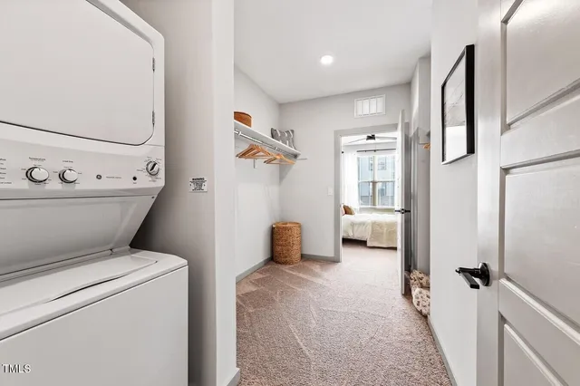 a view of washer and dryer with bathroom in the background