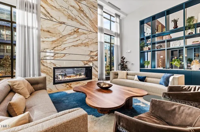 a living room with furniture fireplace and a large window