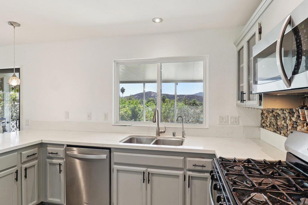 23833 Gymkhana Road Ramona, CA 92065 - Photo 11 of 29 a kitchen with a sink a stove cabinets and a window