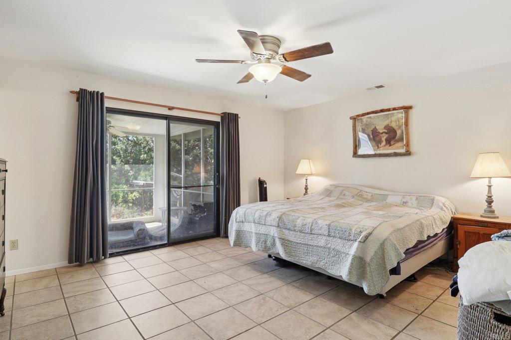 23833 Gymkhana Road Ramona, CA 92065 - Photo 14 of 29 a spacious bedroom with a bed painting on wall and a large window