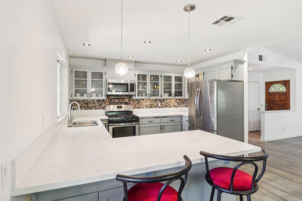 23833 Gymkhana Road Ramona, CA 92065 - Photo 10 of 29 a kitchen with a refrigerator a stove a sink dishwasher with a dining table and chairs