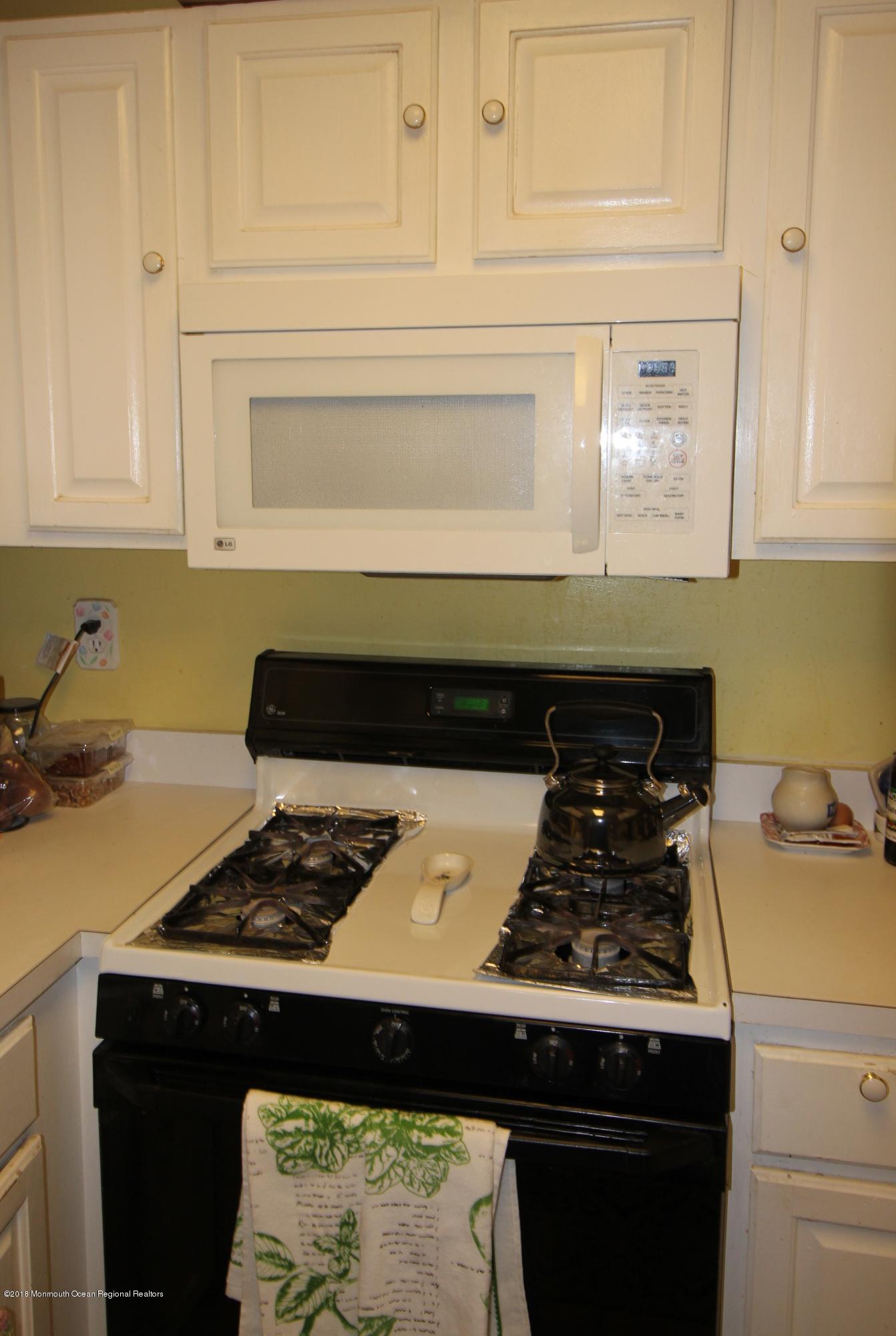 2007 Ridgeview Court, Unit 2007 Parlin, NJ 08859 - Photo 5 of 21 a close view of a stove a microwave and cabinets