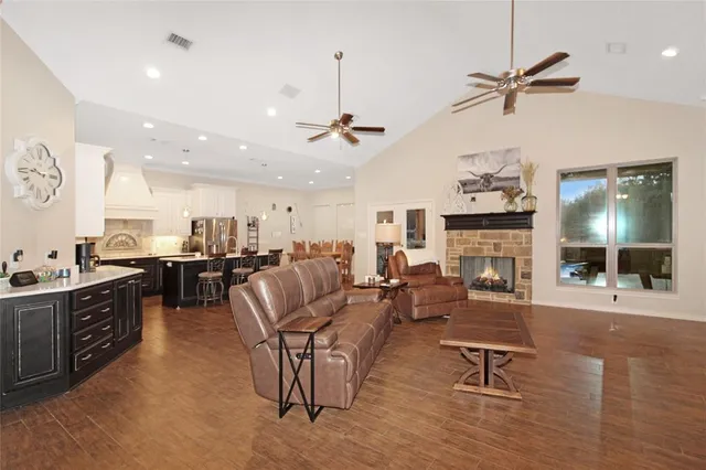 a living room with furniture kitchen view and a chandelier