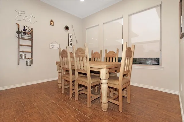 a kitchen with stainless steel appliances a sink dishwasher a refrigerator a stove and white cabinets with wooden floor