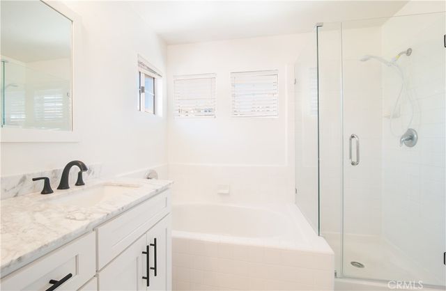 a bathroom with a granite countertop sink a shower and a mirror
