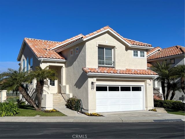a view of a white house with a large window and potted plants
