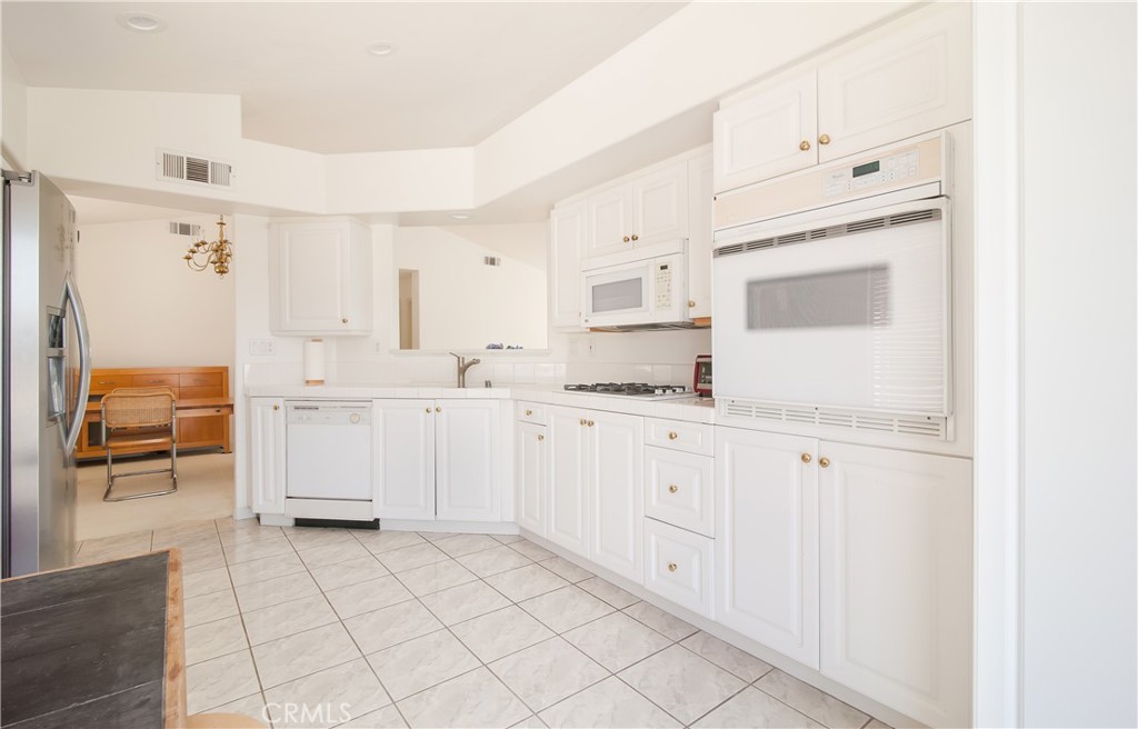 51 Santa Lucia Dana Point, CA 92629 - Photo 6 of 50 a kitchen with white cabinets and white appliances