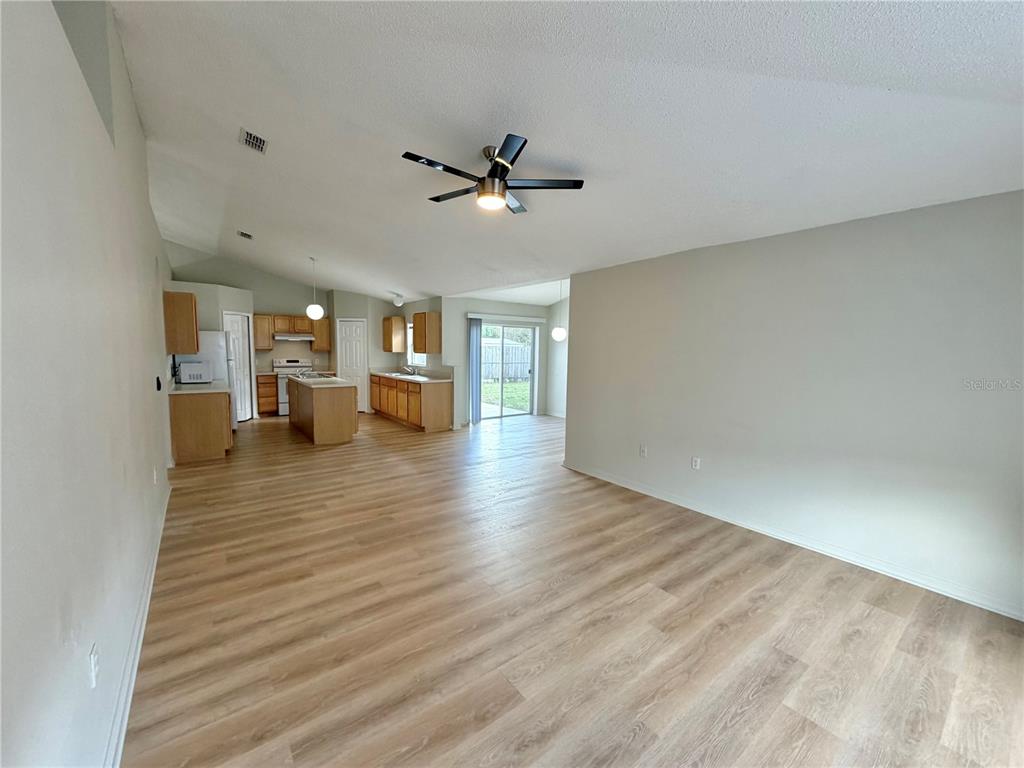 12052 Villa Road Spring Hill, FL 34609 - Photo 16 of 50 an empty room with wooden floor ceiling fan and windows