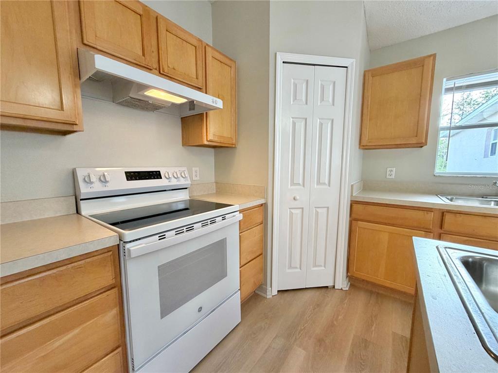 12052 Villa Road Spring Hill, FL 34609 - Photo 20 of 50 a kitchen with a stove top oven cabinets and a wooden floor