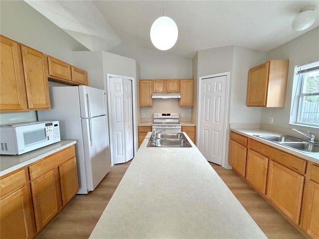 12052 Villa Road Spring Hill, FL 34609 - Photo 7 of 50 a large kitchen with a refrigerator a sink dishwasher a stove and a refrigerator with wooden floor