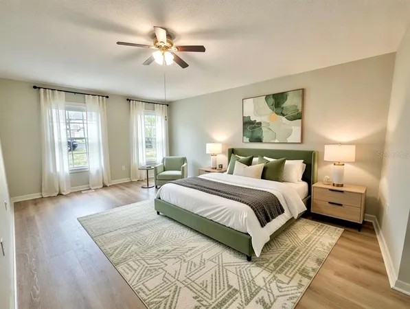 a spacious bedroom with a large bed and a chandelier