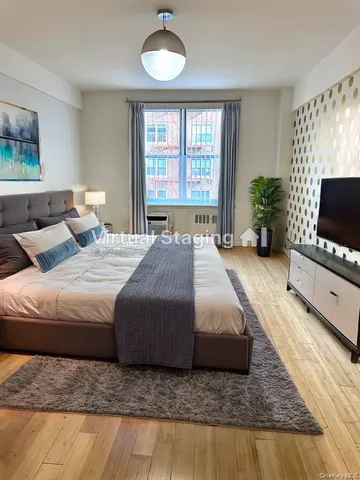 a spacious bedroom with a bed and a flat screen tv