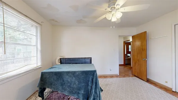 a bedroom with a bed and a chandelier fan