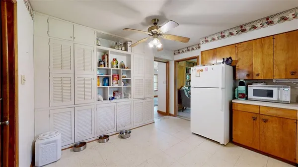 a kitchen with refrigerator and cabinets