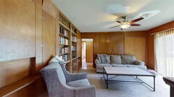 a living room with furniture a ceiling fan and a window