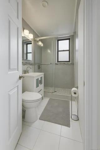 a bathroom with a toilet a sink a shower and mirror