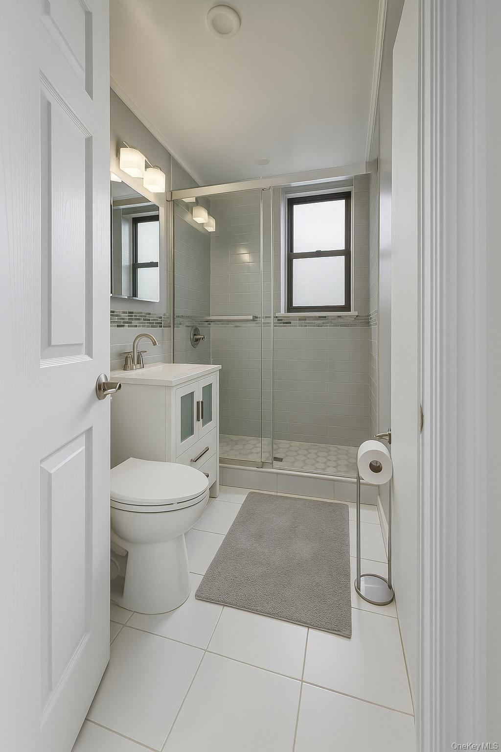 800 Grand Concourse, Unit LEN Bronx, NY 10451 - Photo 2 of 10 a bathroom with a toilet a sink a shower and mirror