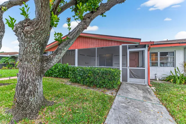 a front view of a house with a yard and potted plants