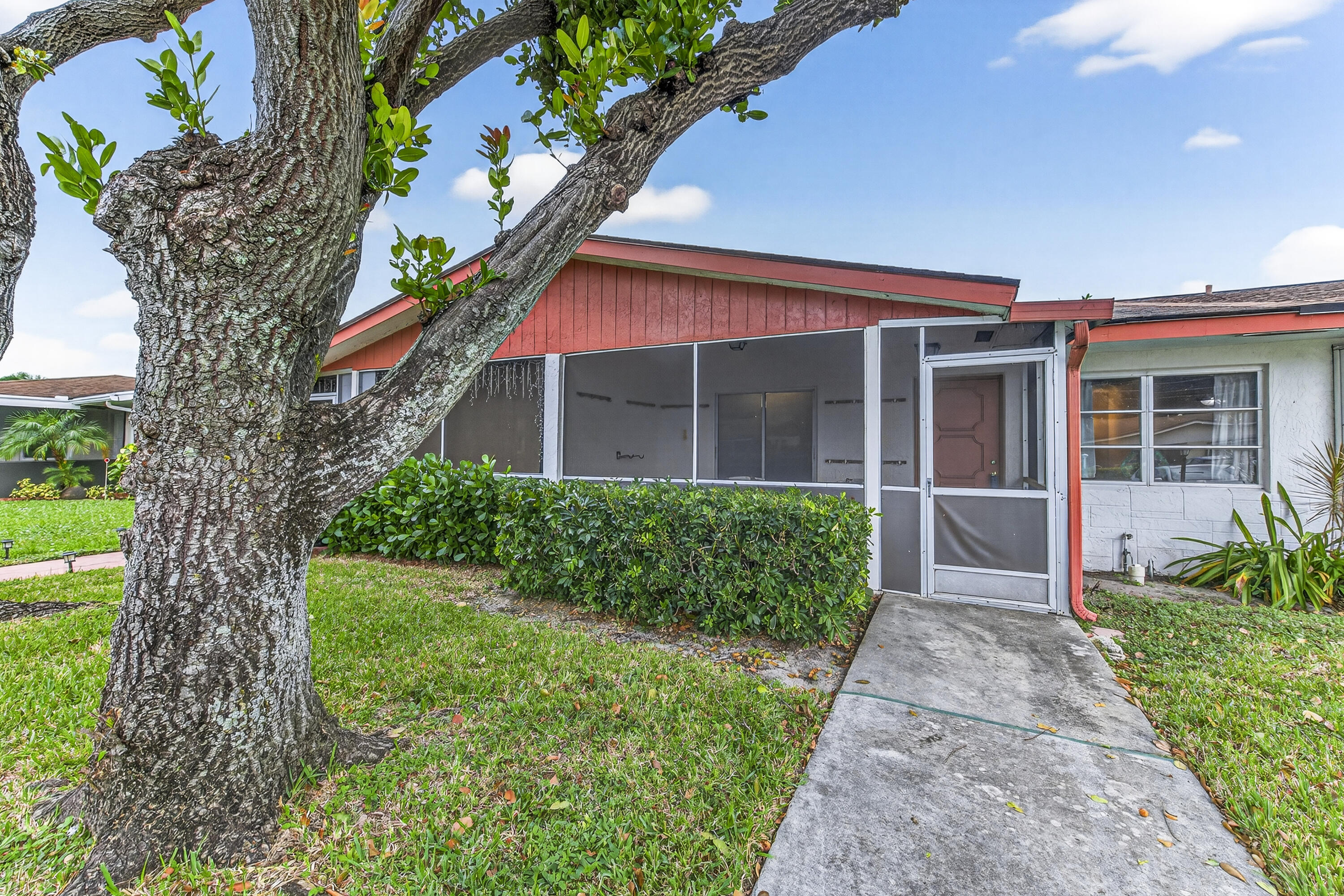 a front view of a house with a yard and potted plants