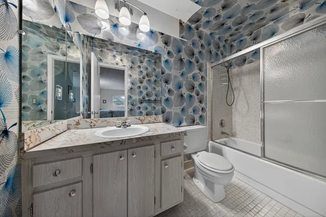 a bathroom with a granite countertop sink toilet and shower